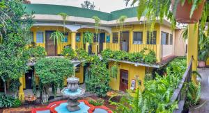 危地马拉安地瓜Posada San Vicente by AHS的享有带喷泉的黄色建筑的外部景色
