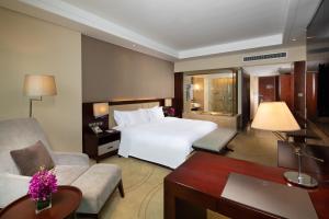 台州台州皇冠假日酒店的一间酒店客房,配有一张白色的床和一张书桌