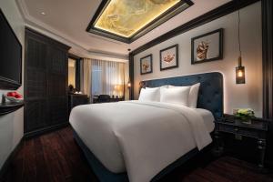 河内La Sinfonía del Rey Hotel & Spa的一间卧室配有一张白色大床和蓝色床头板