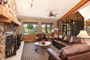 博兹曼山景小屋及套房酒店的客厅配有皮革家具和石墙