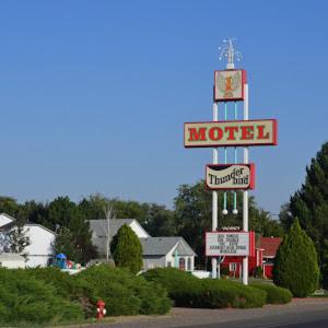 芒廷霍姆Thunder Bird Motel的汽车旅馆的标志,上面有时钟