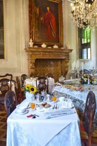 威尼斯大运河皮萨尼宫酒店的一间设有白色桌子和壁炉的用餐室