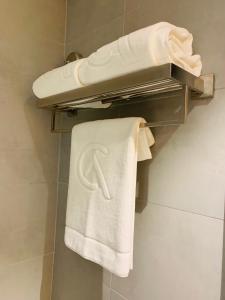 迪拜City Avenue Hotel的浴室提供毛巾架上的白色毛巾