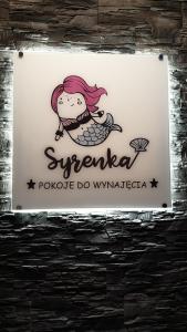 斯蒂格纳Pokoje Morska Syrenka的商店的标志,上面有美人鱼
