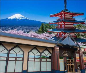 富士河口湖Mt.Fuji Cabin & Lounge Highland Station Inn (Capsule Hotel)的一座建筑,有一座塔,一座山底