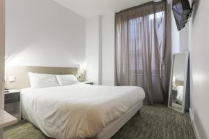罗德兹都可乐切尔酒店的卧室设有一张白色大床和一扇窗户。