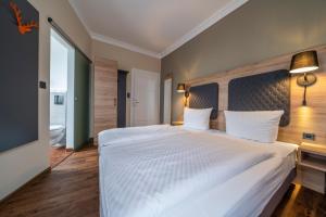 莱茵河畔凯尔黑尔茨酒店的卧室设有一张白色大床和大窗户