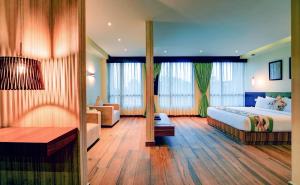 西里古里Udaan Clover Hotel Banquet & Spa的酒店客房,配有床和沙发