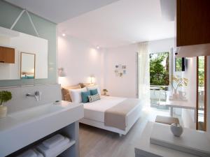 毕达哥利翁Kouros Seasight Hotel的一间白色卧室,配有床和一间浴室