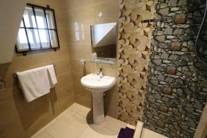 安塞罗亚莱Le Ronce Villa的一间带水槽和石墙的浴室