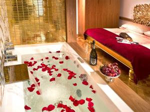 布拉格小小公寓的一间设有浴缸的客房,浴缸上装有红色鲜花
