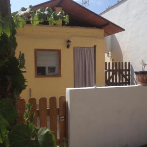 巴尔巴特La casita de Ahinoan.的一座黄色的小房子,设有木栅栏