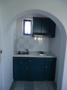 阿吉奥斯普罗科皮奥斯竞技场之星公寓的厨房配有蓝色橱柜和水槽