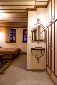 DikoryfoKato Machalas的卧室配有一张床,墙上设有镜子