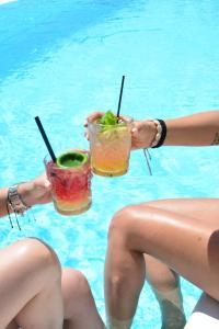 普拉迪斯亚罗斯卡萨格兰德酒店的两名女性坐在游泳池里,喝着饮料