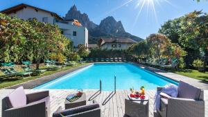 修希黛安娜费琳酒店的一个带椅子的游泳池、一座房子和一座山脉