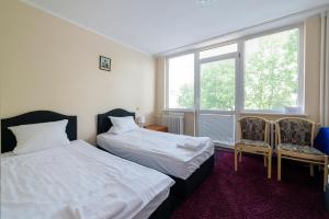 索波特Sopocki Zdrój的一间卧室设有两张床、两把椅子和窗户。