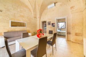 圣潘克拉齐奥萨伦蒂诺Casetta Annarosa by BarbarHouse的用餐室以及带桌椅的起居室。