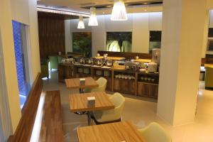 宜兰市欧游连锁精品旅馆-宜兰馆的餐厅设有木桌、椅子和柜台
