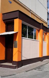 别尔哥罗德Hostel Korona的橙色和白色的建筑,设有窗户