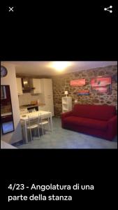 Isola del GiglioAccogliente monolocale的客厅配有红色的沙发和桌子
