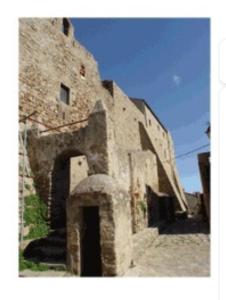 Isola del GiglioAccogliente monolocale的一座古老的石头建筑,前面有拱门