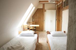 GlinnoKarczma Bełty的小型客房配有两张床和一张桌子。