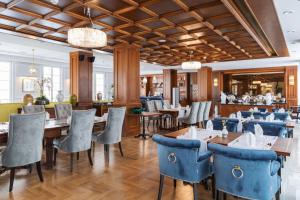 佩济诺克Palace Art Hotel Pezinok的餐厅内带蓝色椅子和桌子的用餐室