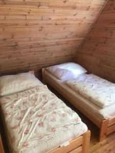翁格罗维茨Ośrodek Wypoczynkowy OAZA的小木屋内带两张床的房间