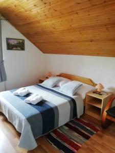 塞里特雷尼科House Viktoria的一间卧室设有一张床和木制天花板