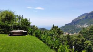 拉维罗Chez Lia - Private garden and tub, sea view close to Villa Eva and Cimbrone, Ravello的山地草原上带长凳的花园