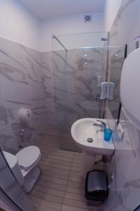 地拉那ART Hostel的白色的浴室设有卫生间和水槽。