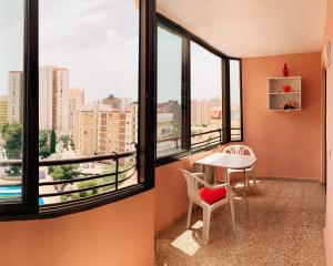 贝尼多姆Edificio Cadiz Benidorm的客房设有桌椅和窗户。