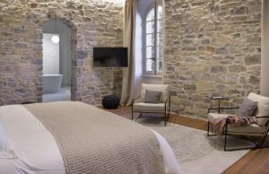 米洛Couvent de la Salette & Spa的一间卧室设有一张床和石墙
