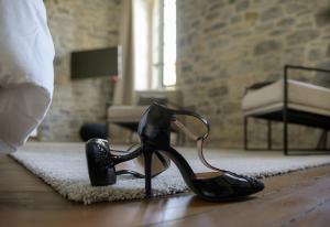 米洛Couvent de la Salette & Spa的卧室里地毯上的一双黑色高跟鞋