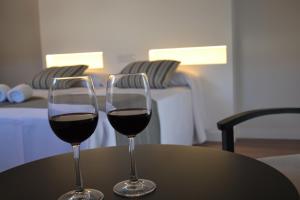 卡拉瓦卡·德·拉·克鲁斯Hotel La Vera Cruz的桌子上放两杯红葡萄酒
