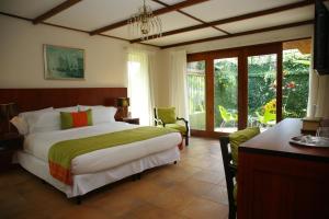 圣何塞特拉萨斯德高尔夫精品酒店的一间卧室配有一张大床和一张桌子及椅子