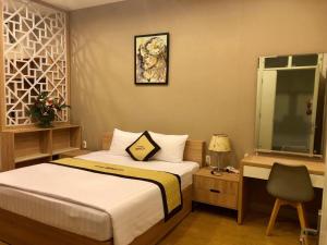 土龙木市比德科酒店的一间卧室配有一张床和一张桌子及椅子