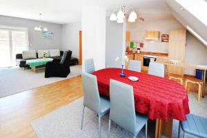 卡尔斯哈根Fewo Urlaubsidyll 2_GUeTH的用餐室以及带红色桌椅的起居室。