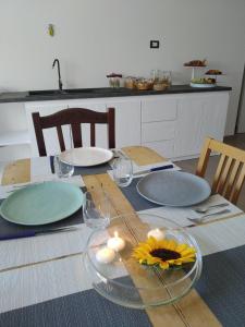 韦列Casa PARADISO Camere in Affitto的桌子上放有盘子和玻璃杯,还有向日葵
