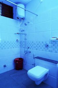 迈索尔UNNATHI SUITES的白色的浴室设有卫生间和淋浴。