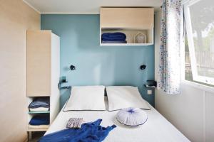 滨海皮里亚克Camping MON CALME的一间卧室配有一张蓝色墙壁的床和一扇窗户