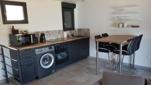 韦尔东的圣克鲁瓦La Frache的厨房配有洗衣机和木桌。