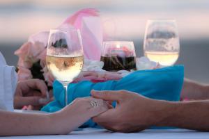 高兰Andaman Lanta Resort - SHA Extra Plus的一群坐在桌子上的人,戴着酒杯