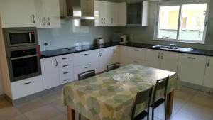 奎特里拉Villa 48的厨房配有白色橱柜和桌椅