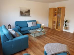 格洛米茨Appartementhaus Diana的客厅配有蓝色的沙发和桌子
