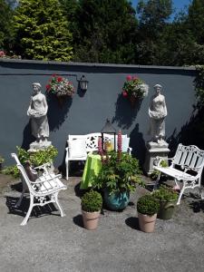 班敦Saint Martin's Bed and Breakfast的庭院设有椅子、盆栽植物和雕像