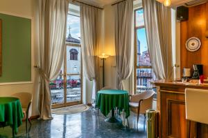 博洛尼亚Hotel San Donato - Bologna centro的客房设有桌椅和窗户。