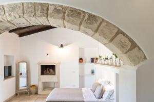 阿卡亚马塞里亚维多利亚乡村民宿的一间卧室配有一张带石拱门的床