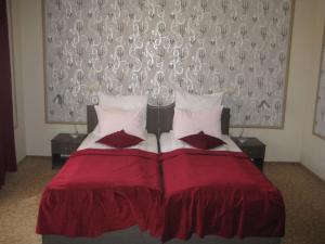 锡比乌萨弗里达旅馆的一间卧室配有红色的床和两个枕头